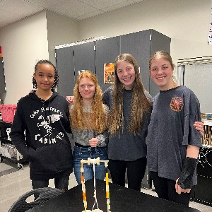 Students standing by their rock-moving machine.